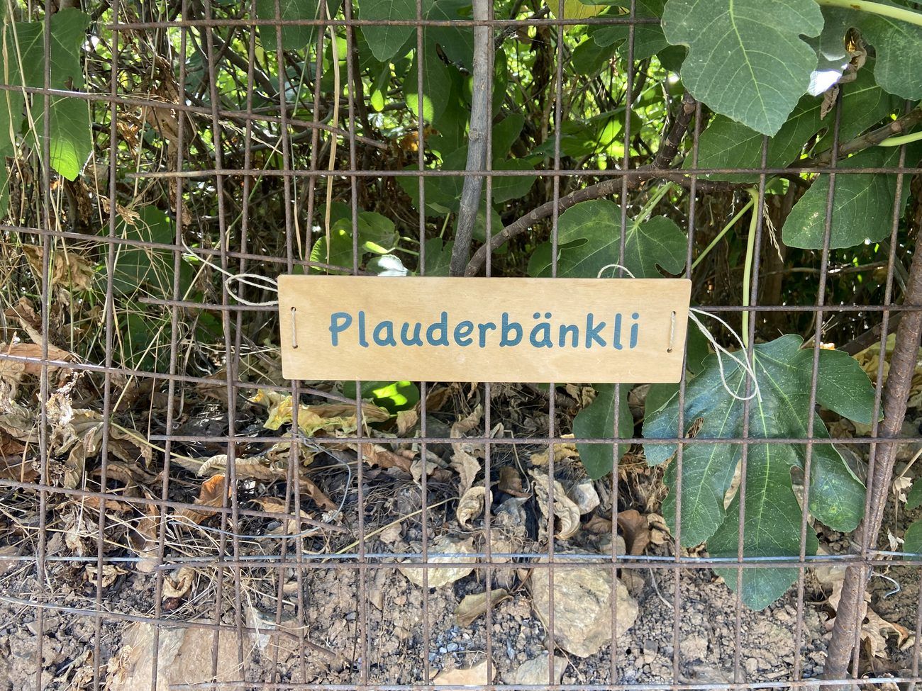 Das Schild Plauderbänkli am Gitter